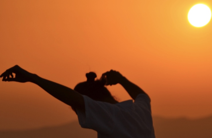 Donna medita nella natura al tramonto 