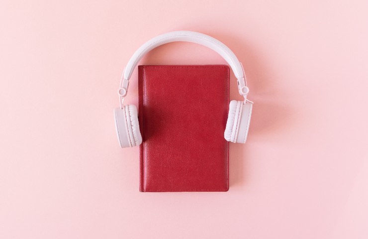 Cuffie per ascoltare la musica attorno a un libro rosso 