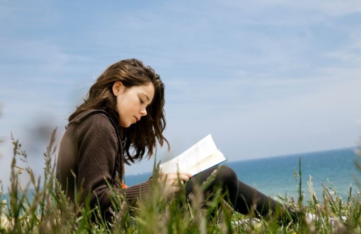 Ragazza legge un libro all'aperto