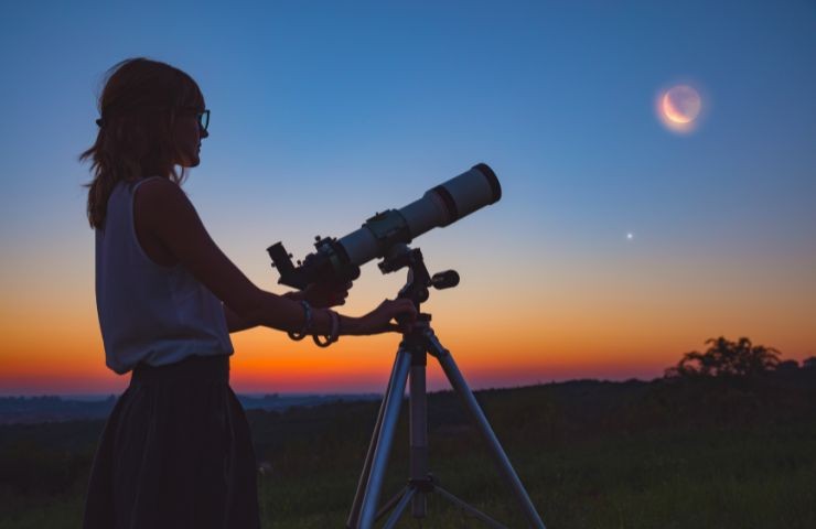 Ragazza osserva il cielo con il cannocchiale
